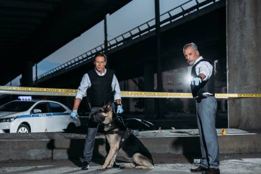 Erkek polis memuru meslektaşı ile köpek üstünde kira kontratı çapraz satırı olay yerinde parmak tarafından işaret 