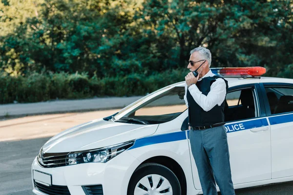 Поліцейський Середнього Віку Куленепробивному Жилеті Говорить Радіо Встановленому Біля Автомобіля — стокове фото