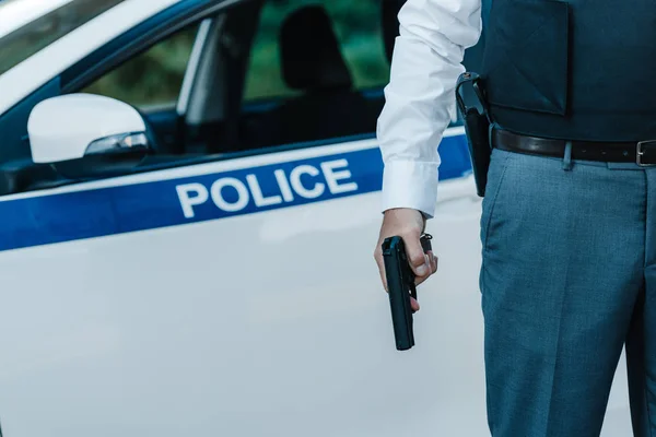 Beskuren Bild Polis Skottsäker Väst Holding Pistol Nära Bilen Gatan — Stockfoto