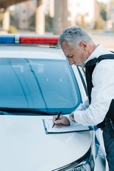 Side View Focused Male Police Officer Writing Clipboard Car Street — Free Stock Photo