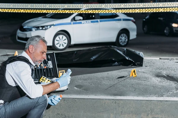 Vista Laterale Del Poliziotto Che Raccoglie Prove Vicino Confine Sulla — Foto Stock