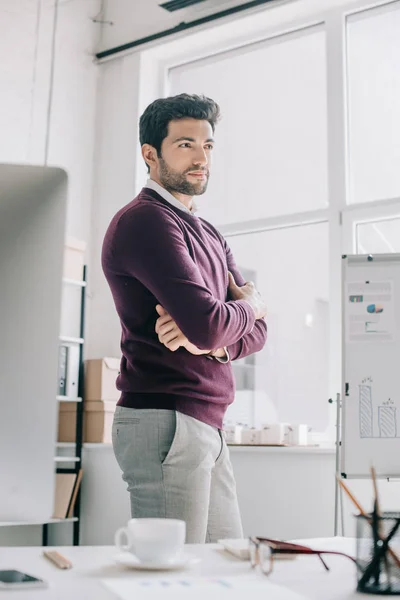 Przystojny Projektanta Bordowy Sweter Stojąc Skrzyżowanymi Rękami Odwracając Biurze — Darmowe zdjęcie stockowe