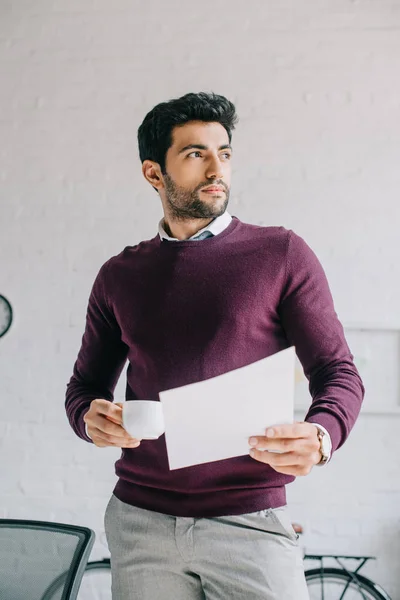 Tampan Desainer Burgundy Sweater Memegang Secangkir Kopi Dan Dokumen Kantor — Stok Foto