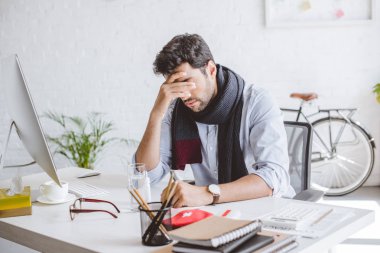 alnına dokunmak ve Office masada oturan fularlı hasta Yöneticisi