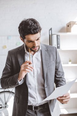 belgeleri okuma ve kalem Office ile yanak dokunmadan dalgın işadamı