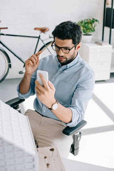 Serious Architect Using Smartphone Architecture Model Office — Free Stock Photo