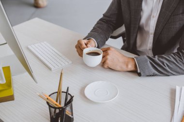 kahve masasında ofiste tutan işadamı kırpılmış görüntü