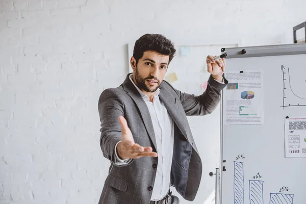 Gutaussehender Geschäftsmann Gestikuliert Während Sein Projekt Auf Flipchart Büro Präsentiert — Stockfoto