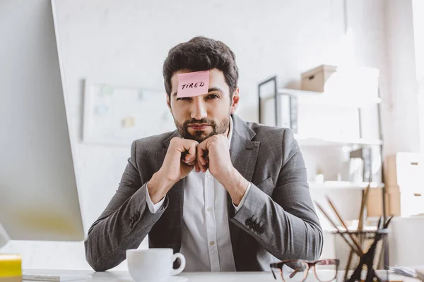 Geschäftsmann Sitzt Mit Papieraufkleber Auf Der Stirn Mit Amtsmüdem Wort — Stockfoto