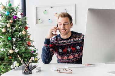 modern ofis Smartphone cep telefonu ile konuşurken Noel kazağı işadamı   