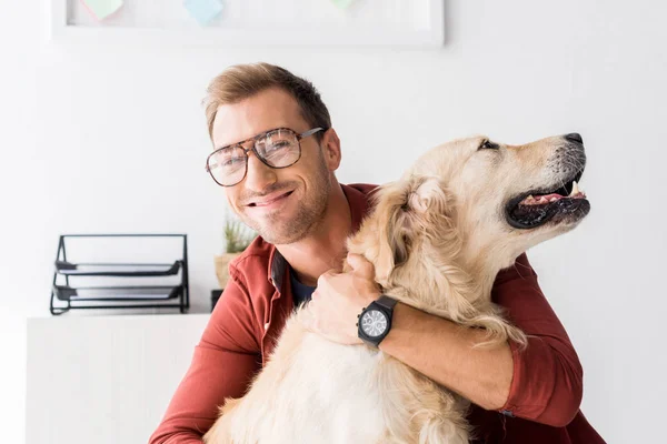 微笑的人拥抱金黄猎犬狗 — 免费的图库照片