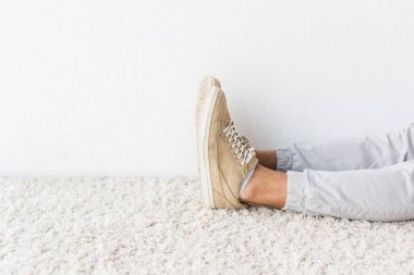 cropped view of casual man on beige rug  clipart