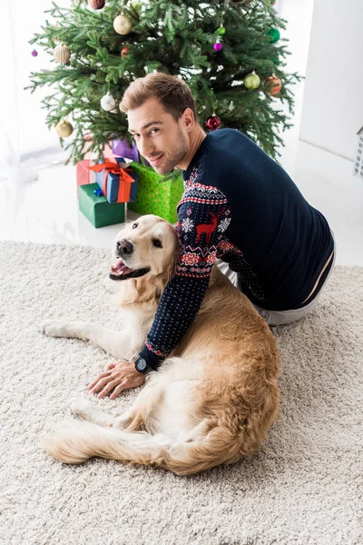 Man Kerst Trui Zit Buurt Van Golden Retriever Hond — Stockfoto