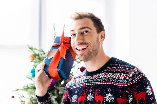 Glimlachende Man Christmas Sweater Met Doos Van Gift Buurt Van — Gratis stockfoto