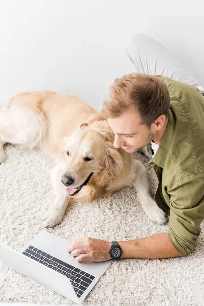 Mann Mit Hund Auf Dem Boden Liegend Und Mit Laptop — kostenloses Stockfoto