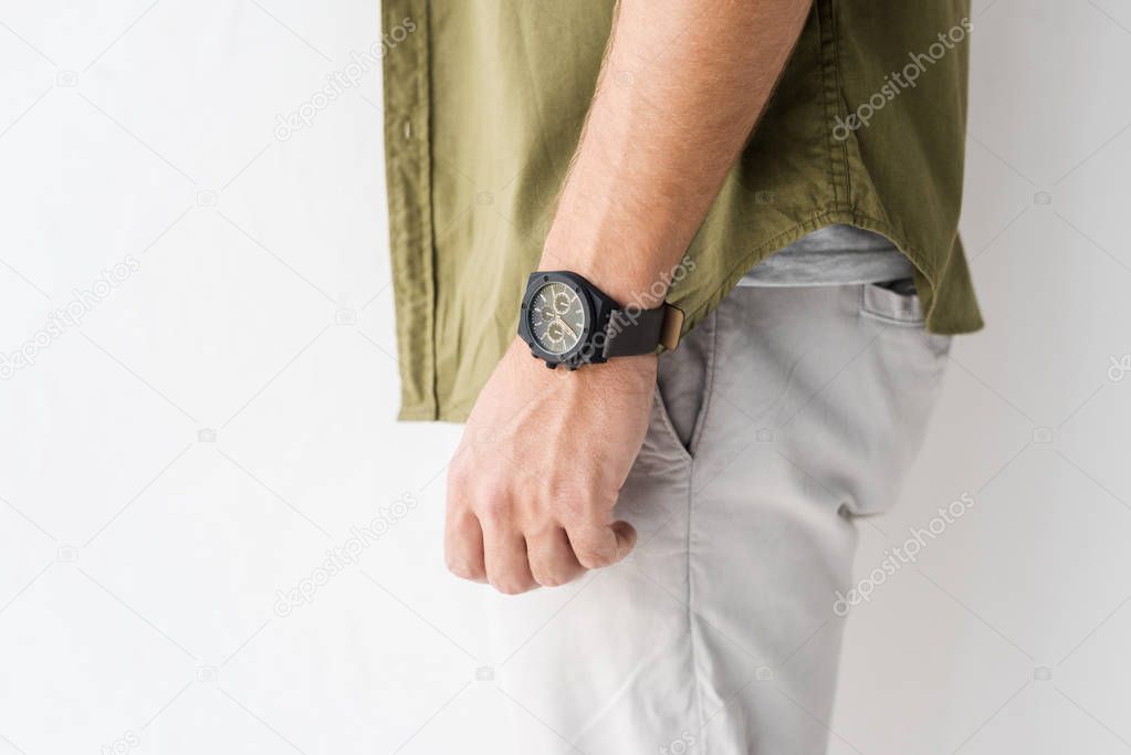 cropped view of male hand with wristwatch against white wall