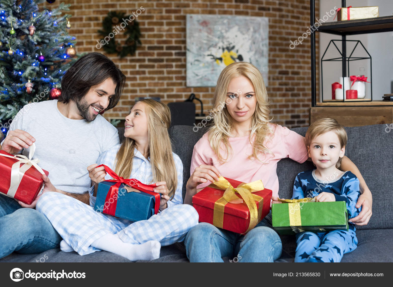 クリスマス プレゼントを押し 家で一緒に座っている 人の子供を持つ美しい幸せな家族 無料のストック写真 C Igorvetushko