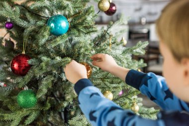 cropped shot of child in pajamas decorating christmas tree  clipart