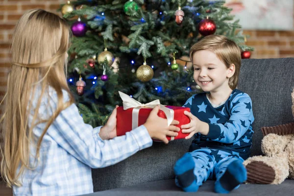 家でクリスマス プレゼントを抱えてパジャマでかわいい幸せな子供たち  — 無料ストックフォト