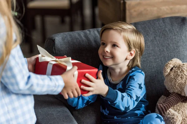 Schnappschuss Von Kind Überreicht Weihnachtsgeschenk Glücklichen Kleinen Bruder — Stockfoto