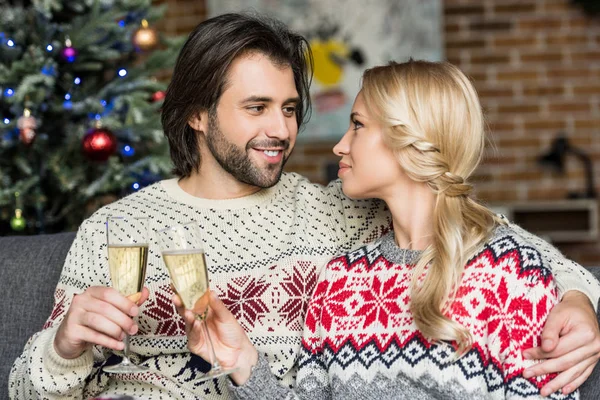 幸せな若いカップルお互いに笑みを浮かべて クリスマスの時にシャンパンを飲む  — 無料ストックフォト