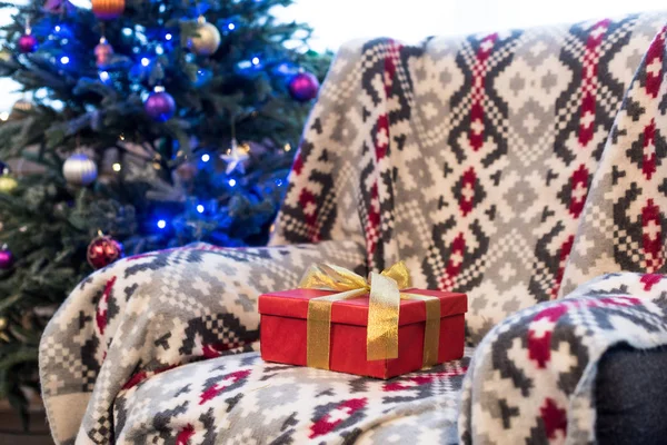 Confezione Regalo Rossa Con Fiocco Dorato Sul Divano Albero Natale — Foto Stock