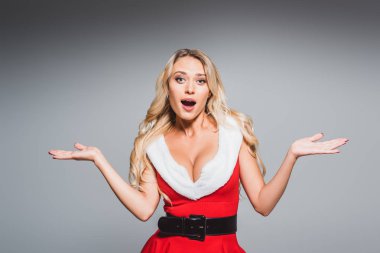 gri arka plan üzerinde izole omuz silkme hareketi yapıyor santa içinde sürpriz güzel kadın 
