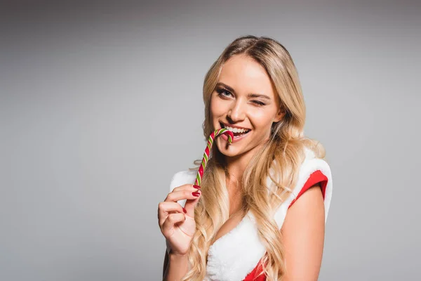 Happy Young Woman Santa Dress Eating Striped Christmas Stick Isolated — Free Stock Photo