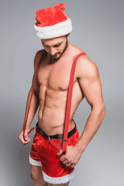Bello Uomo Muscoloso Cappello Natale Tenendo Bretelle Guardando Giù Isolato — Foto Stock