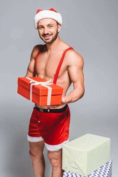 Gelukkig Gespierde Santa Kerstmuts Shorts Houden Doos Van Gift Geïsoleerd — Stockfoto