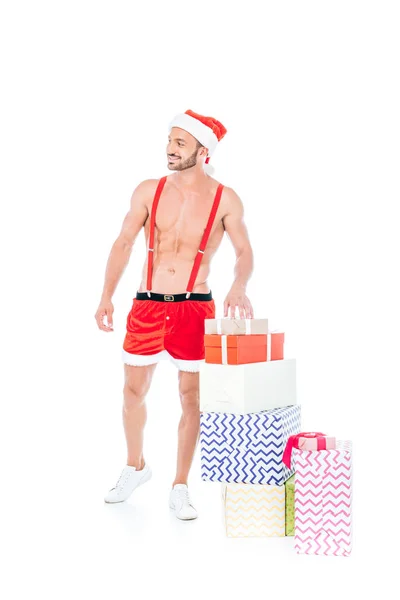 Shirtless Muscular Man Christmas Hat Standing Pile Gift Boxes Isolated — Free Stock Photo