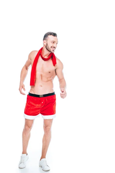 快乐的无上衣肌肉男子在圣诞节短裤和红色围巾孤立的白色背景 — 免费的图库照片