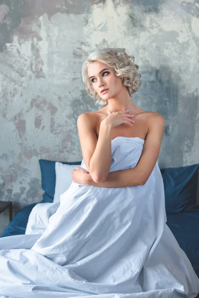 Atraente Jovem Mulher Sentada Cama Coberta Com Cobertor Branco — Fotografia de Stock