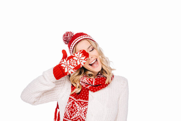 happy young woman in red hat, scarf and mitten laughing isolated on white
