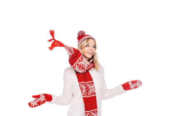 beautiful smiling young woman in hat, scarf and mittens looking away isolated on white