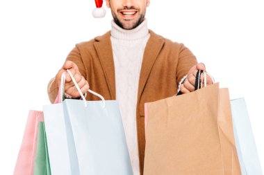 Noel Baba şapkası alışveriş torbaları üzerinde beyaz izole tutmak gülümseyen sakallı adamın kırpılmış atış