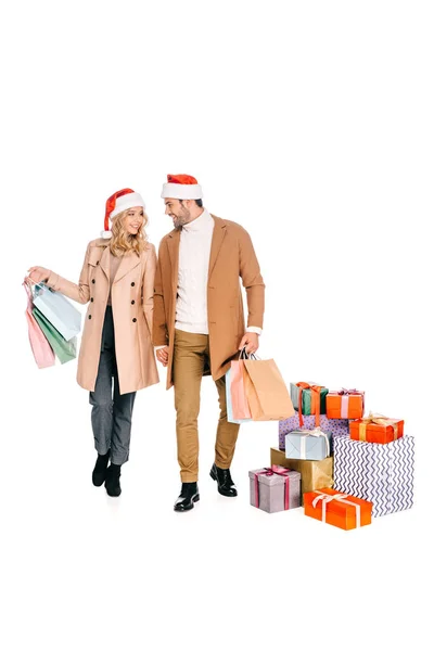 Sonriente Joven Pareja Santa Sombreros Sosteniendo Bolsas Compras Caminando Cerca — Foto de Stock