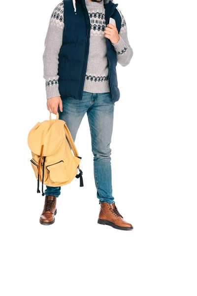裁剪拍摄的时尚年轻的旅客持有背包和智能手机孤立的白色 — 图库照片