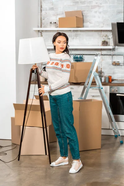 Young Woman Putting Lamp Kitchen Relocation New Home — Free Stock Photo