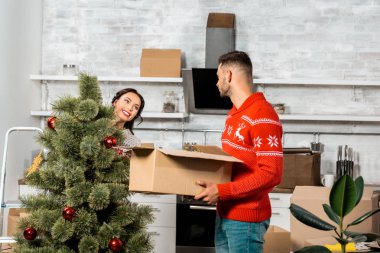 karton kutu Noel ağacı evde mutfak dekorasyon onun kız arkadaşı süre tutan adam yan görünüm 
