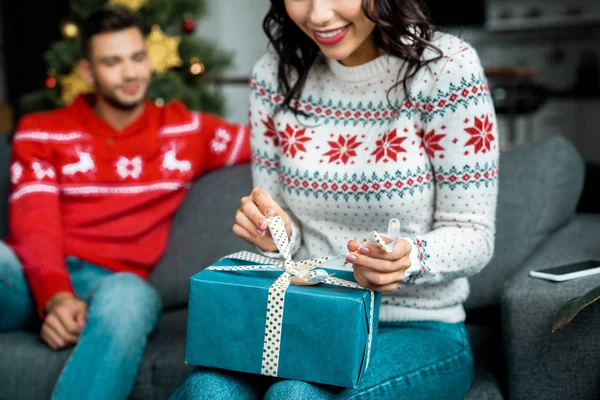Partial View Woman Untying Christmas Present While Her Boyfriend Sitting — Stock Photo, Image