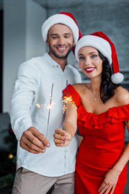 seçici odak Noel genç çiftin holding sparkles evde şapka
