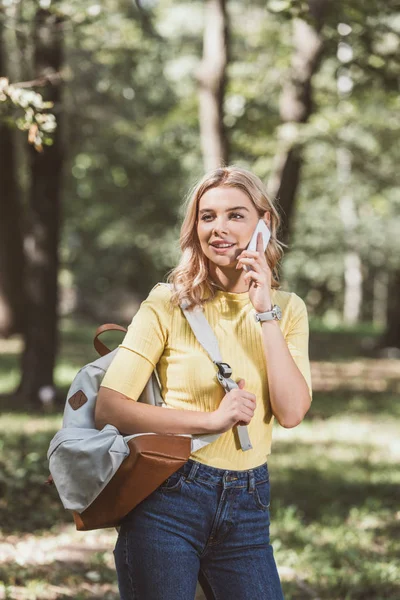 Potret Wanita Muda Dengan Ransel Berbicara Smartphone Taman — Foto Stok Gratis