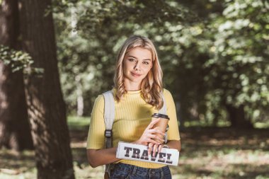 Genç Sarışın kadın kahve ile gidip gazete Park seyahat portresi