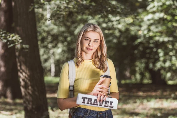 年轻金发女郎的肖像和咖啡去旅游报纸在公园 — 图库照片