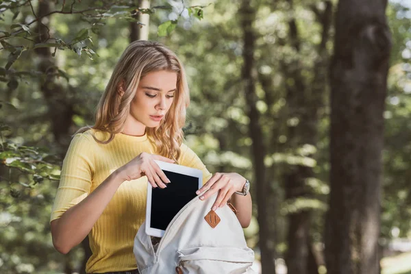 Mulher Loira Colocando Tablet Digital Com Tela Branco Mochila Parque — Fotografia de Stock