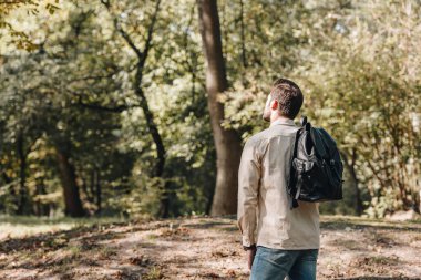 arkadan görünüşü ile sonbahar park çantada şık genç adam