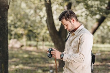 turist fotoğraf makinesi ile yan görünüm sonbahar parkta eller