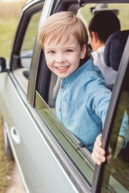 mutlu küçük çocuk arabası ile babası doğası ve kameraya bakıyor