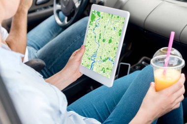 kadın kırpılmış atış ile plastik bardak portakal suyu tablet harita ekranda araba ile kullanma